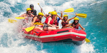 girls whitewater rafting on a river, looking excited